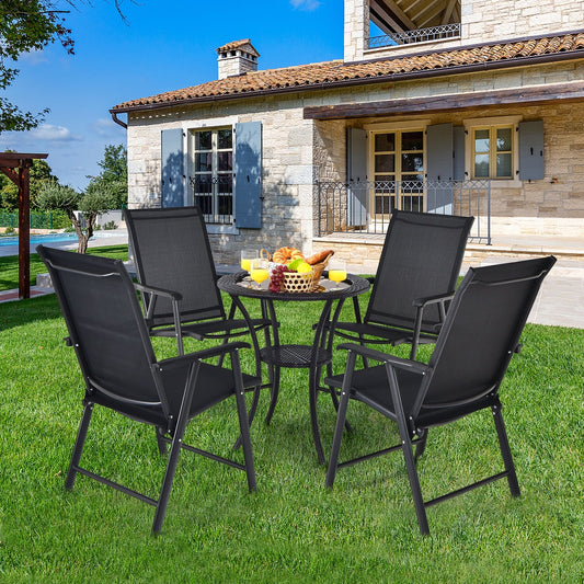 4-Pack Patio Folding Chairs Portable for Outdoor Camping-Black set on a lawn around a table in front of a house
