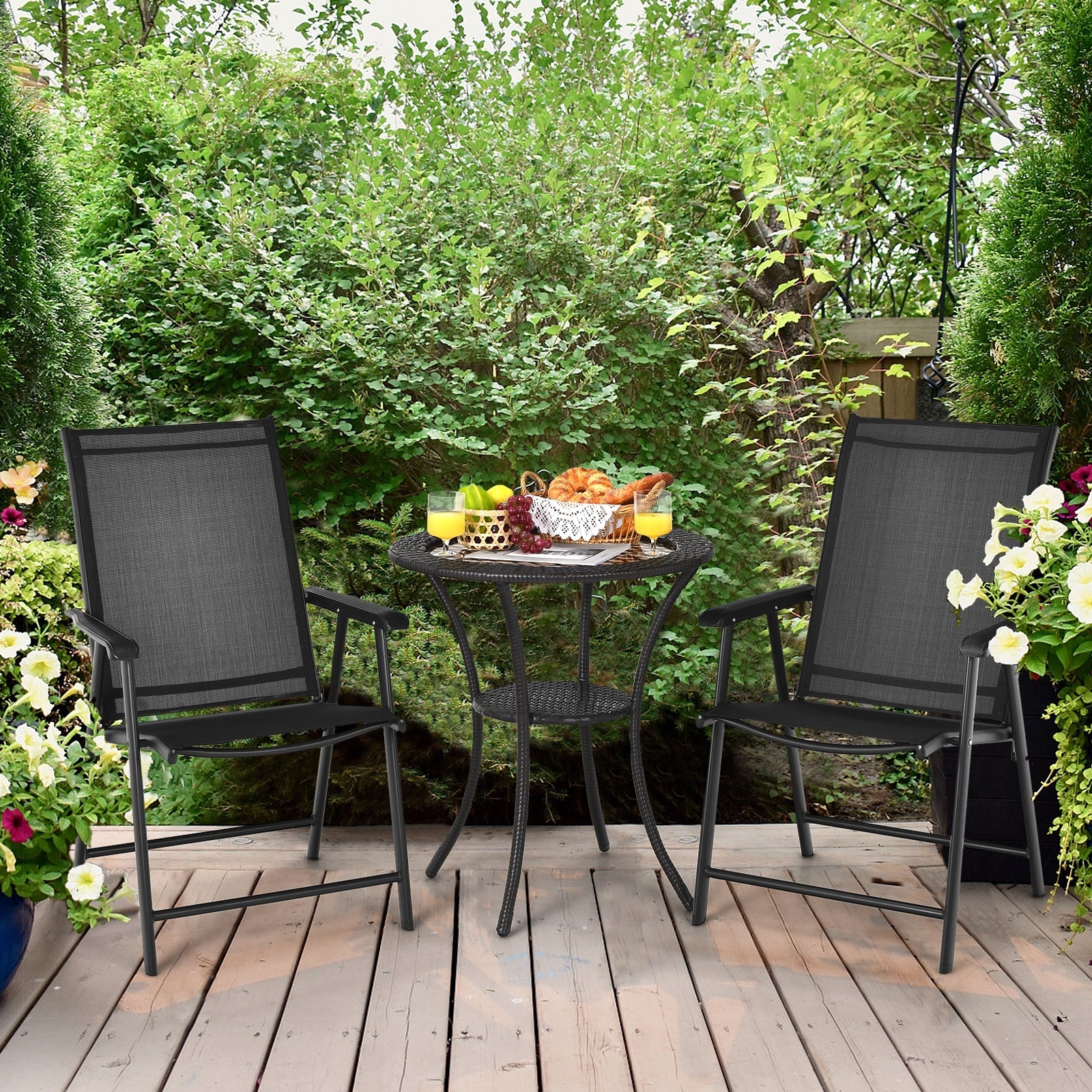 Outdoor setup featuring 4-Pack Patio Folding Chairs Portable for Outdoor Camping-Black beside a table with snacks and drinks on a patio.