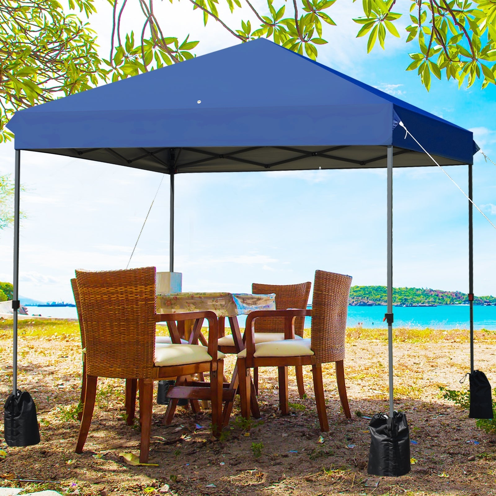 8x8 Pop Up Canopy Tent w/Roller Bag-Blue providing shade on a sunny beach area with chairs and table underneath.