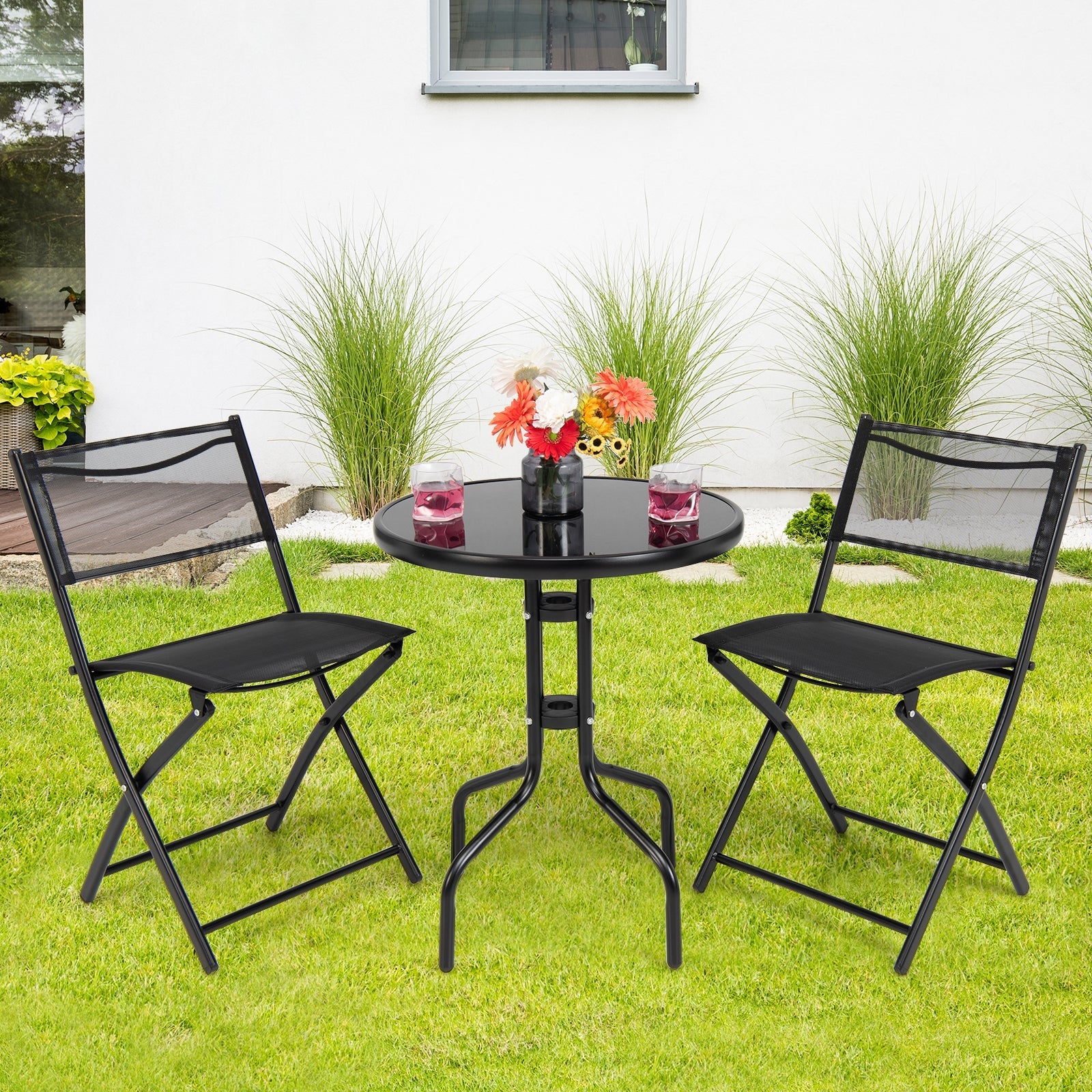 3 Pieces Folding Bistro Table Chairs Set for Indoor and Outdoor in garden setting with round table and 2 folding chairs.
