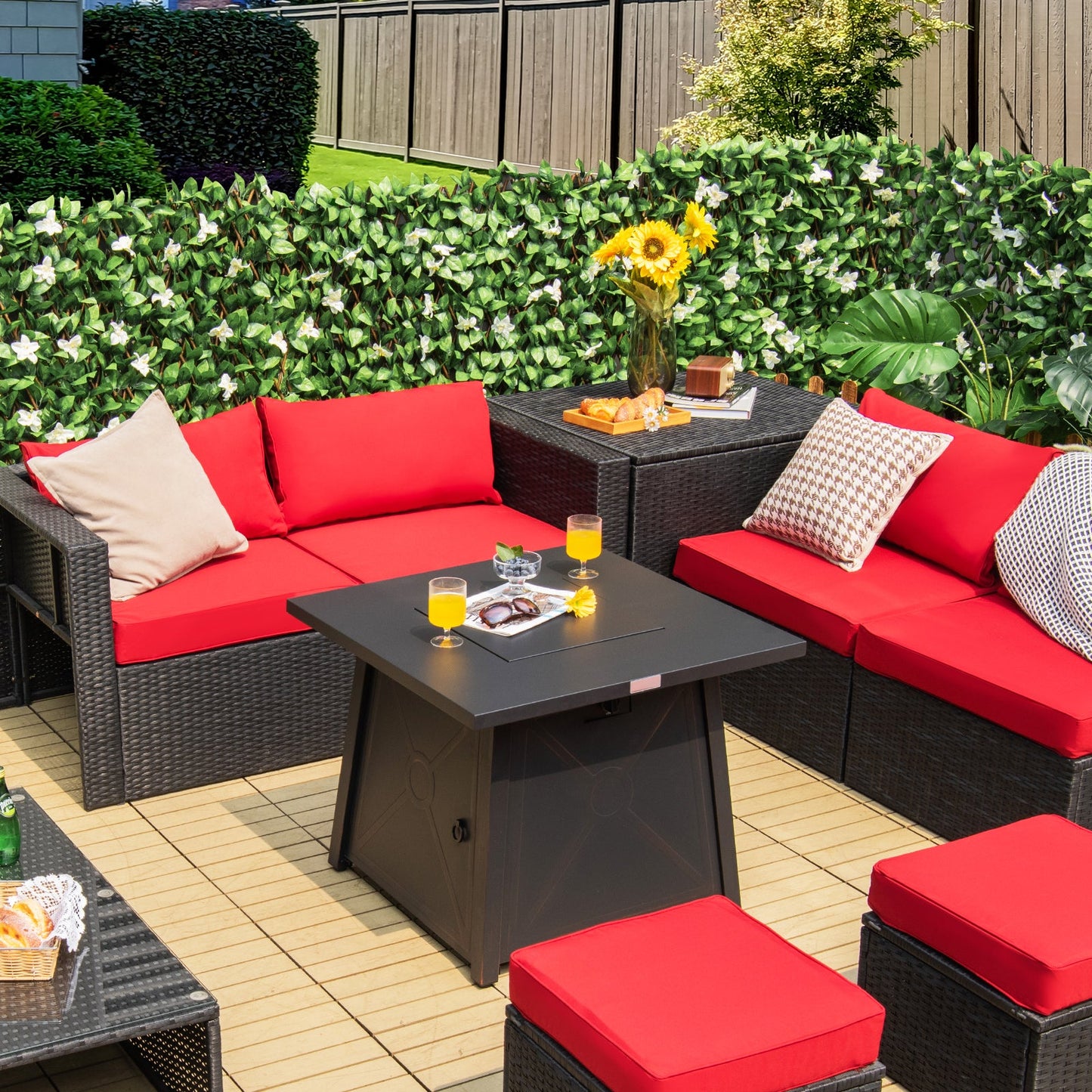 30 Inch Square Propane Gas Fire Table with Waterproof Cover on patio with red cushion seating and foliage backdrop