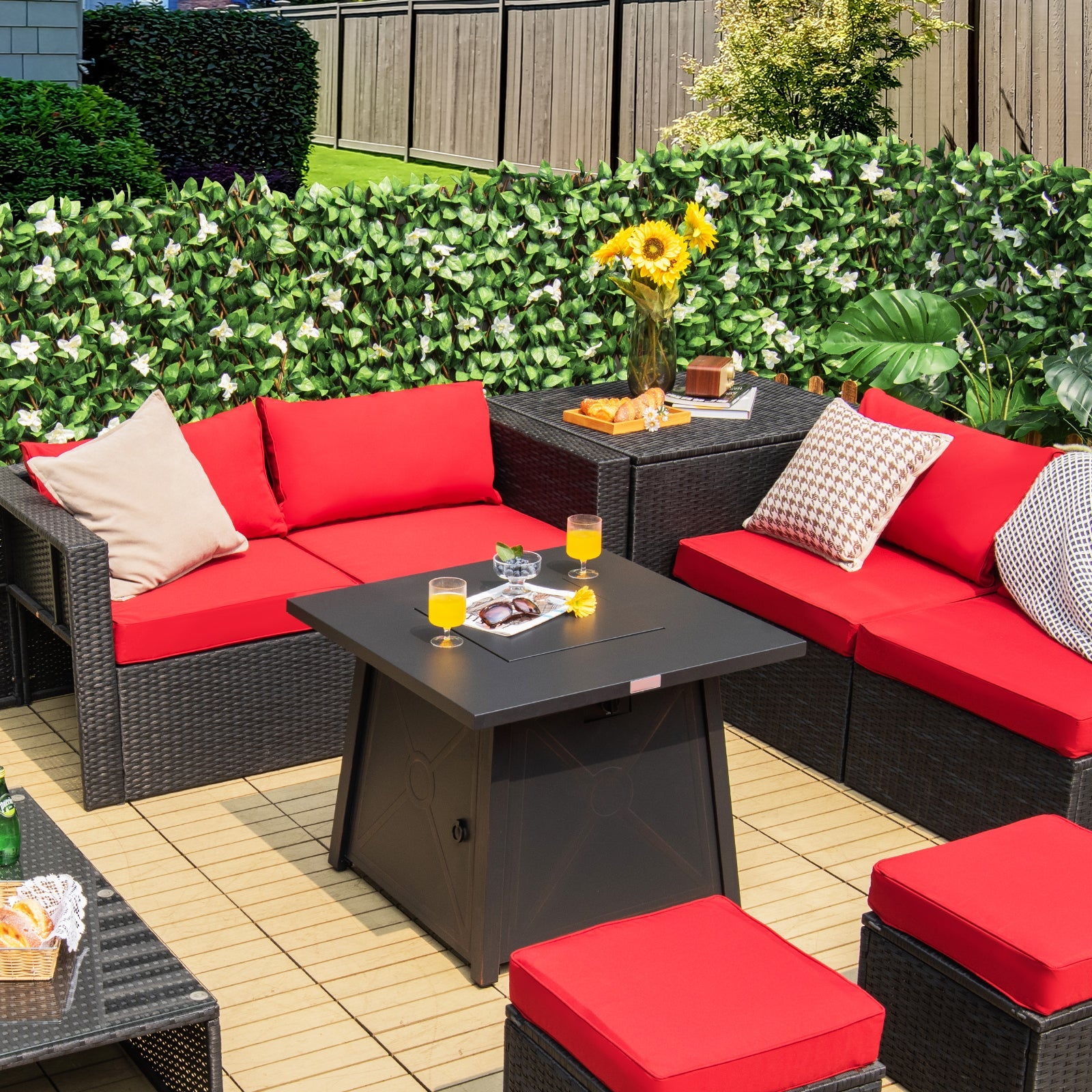 30 Inch Square Propane Gas Fire Table with Waterproof Cover on patio with red cushion seating and foliage backdrop