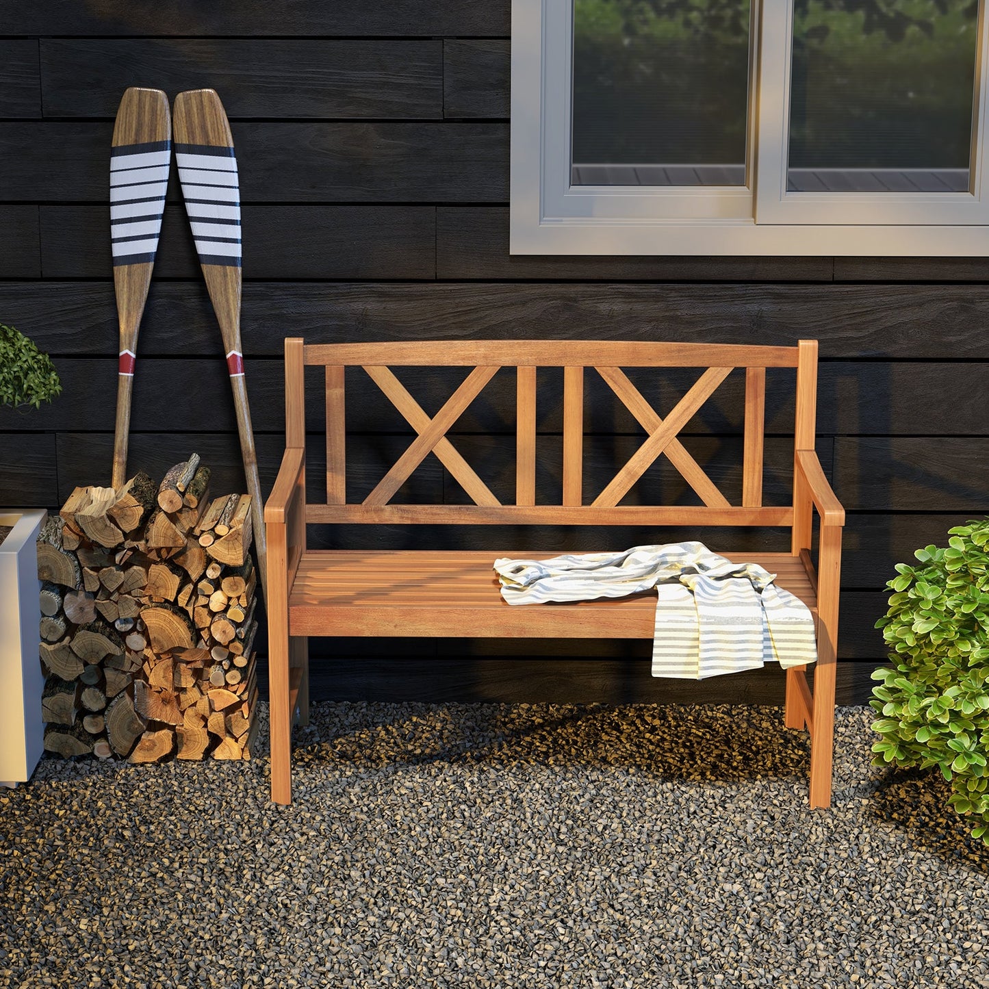 2-Person Wood Outdoor Bench with Cozy Armrest and Backrest on patio with decorative paddles and firewood stack