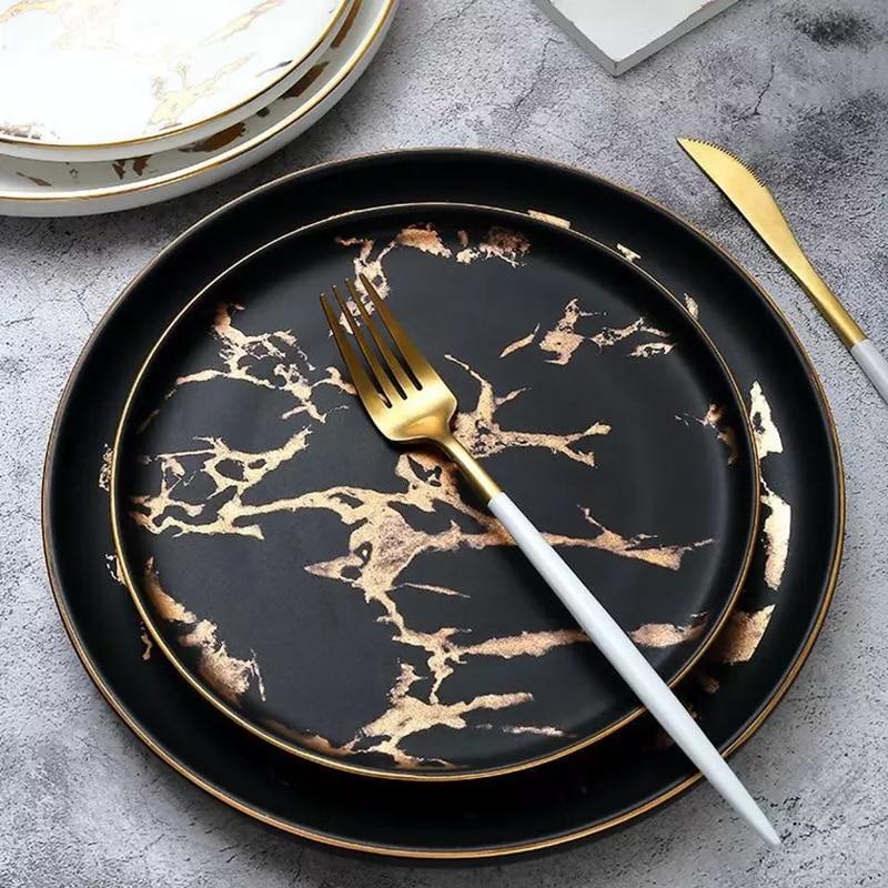 Lighting Flat Plates Nordic Collection - Marble pattern ceramic dinner plates with bronze cutlery on a marble surface