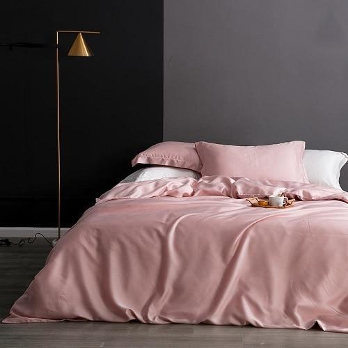 Karen Solid Color Lyocell Duvet Cover Set in pink on a modern bed with decorative pillows and a sleek lamp in a stylish bedroom.