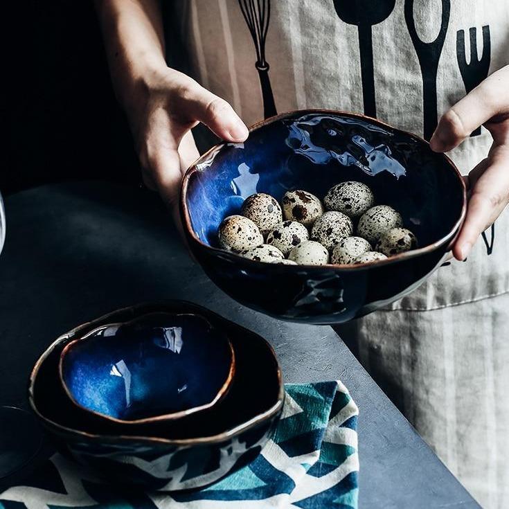 European Porcelain Deep Bowl in dark blue glaze holding quail eggs on a textile, showcasing handmade craftsmanship and eco-friendly design.
