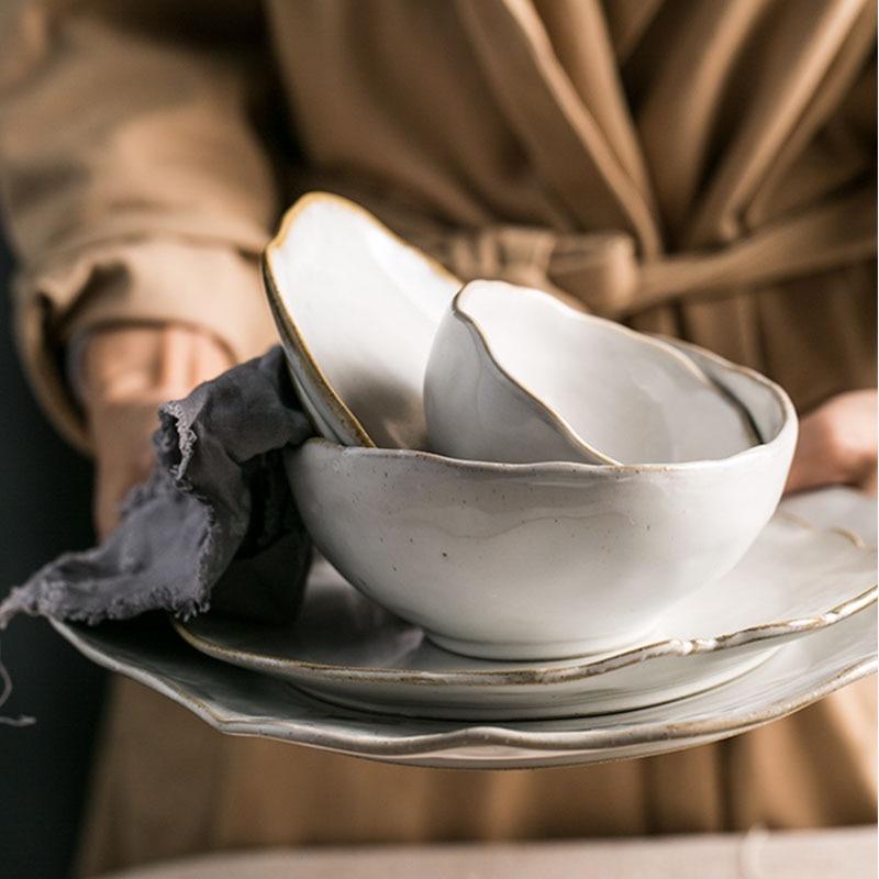 Thetis Tableware Set with vibrant glazes and hand-thrown ceramic design, shown in stackable plates and bowls, perfect for your meals.