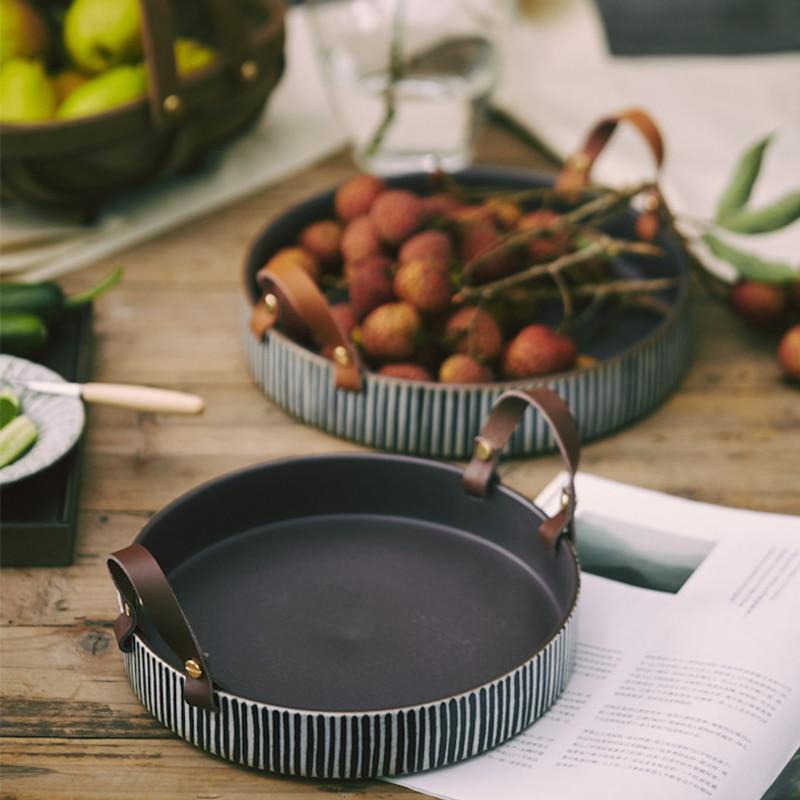 Exclusive Striped Ceramic Plate with Leather Handle displaying fruits on a wooden dining table