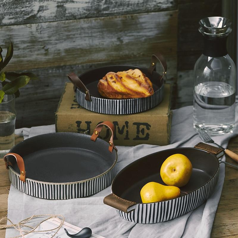 Exclusive Striped Ceramic Plate with Leather Handle displaying fruits and snacks on a rustic dining setup.