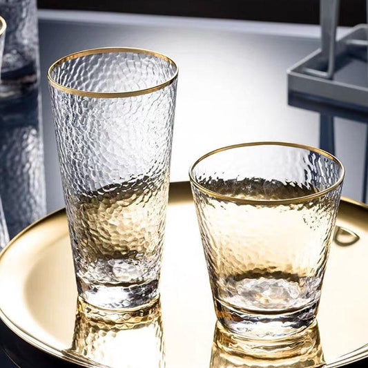 Golden Rim Clear Whiskey & Water Glass set on a reflective tray, eco-friendly round transparent glasses with a textured design.