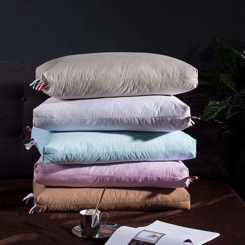 Stack of colorful pillows on bed featuring Giovanni Goose Down Pillows Cotton Made Set of 2, perfect for modern bedroom decor.