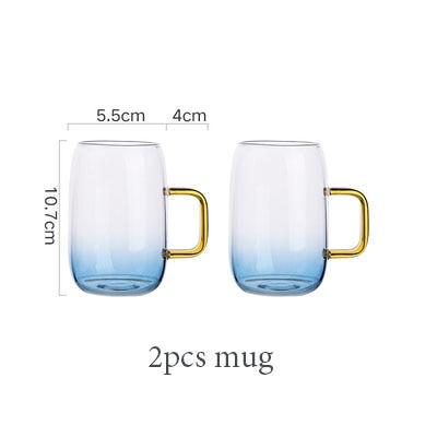 Set of two transparent rounded glass mugs with blue tint and gold handles, measuring 10.7cm tall, 5.5cm wide, labeled '2pcs mug'.