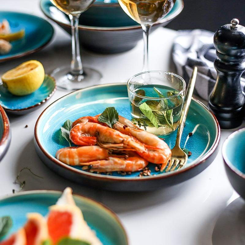 Rosmerta Bowls And Dishes showcasing Japanese-style porcelain plates with a seafood meal, fork, and glass, emphasizing eco-friendly design.