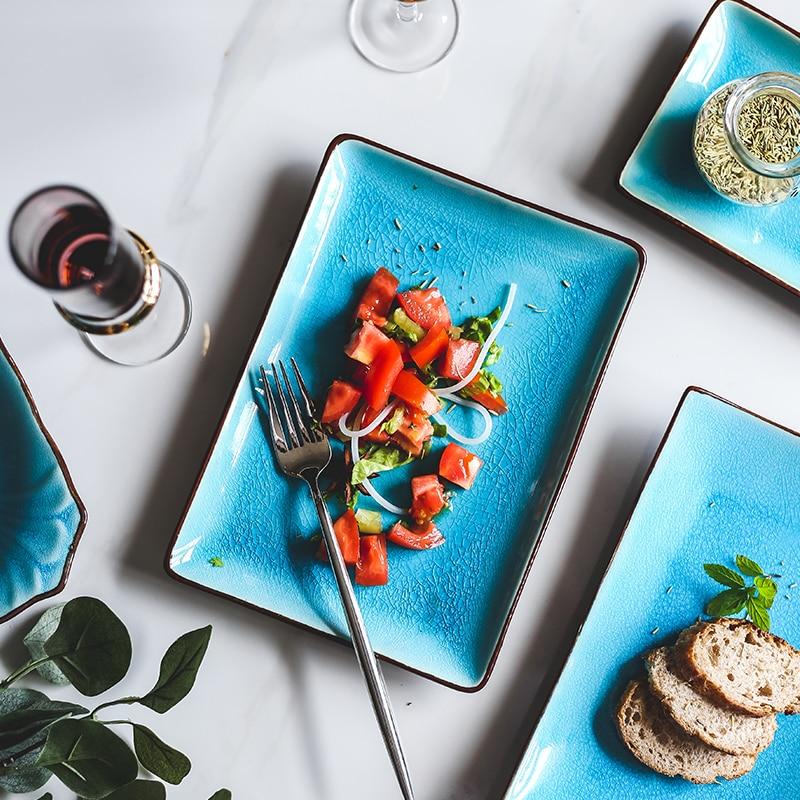 Rosmerta Bowls And Dishes with salad on blue porcelain plates, eco-friendly ceramic, perfect for Japan-style dining.