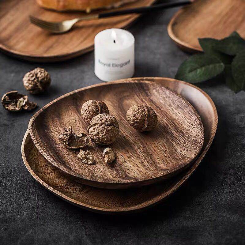 Mateo Oval Wood Board Set 5-Piece displayed with walnuts on a dark table
