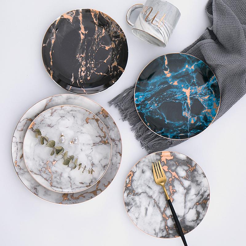 Selene Plates set in black, blue, and light gray with strip pattern in round ceramic design, showcasing beautiful lighting painting.