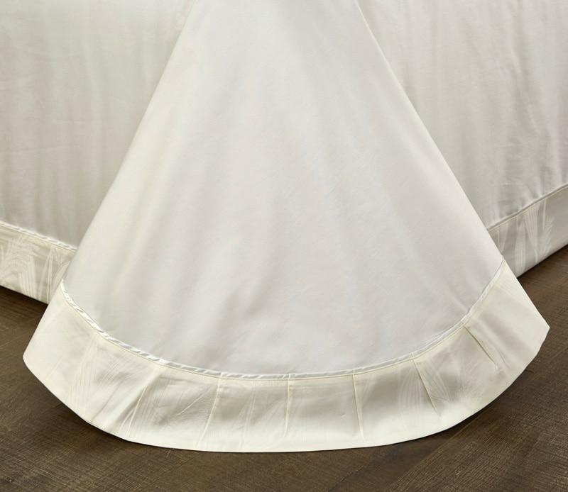 Close-up of Warm White Lancelot Duvet Cover Set (Premium Egyptian Cotton) (Jacquard) fabric and stitching detail on bed.