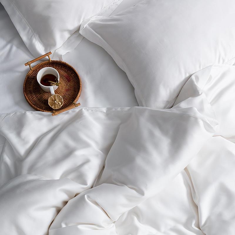 Karen Solid Color Lyocell Duvet Cover Set in white, featuring smooth Tencel Lyocell fabric, styled with a cup of tea on a tray.