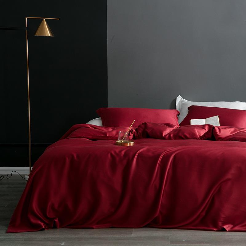 Karen Solid Color Lyocell Duvet Cover Set in a rich red hue, displayed in a modern bedroom with a boho style and minimalist decor.