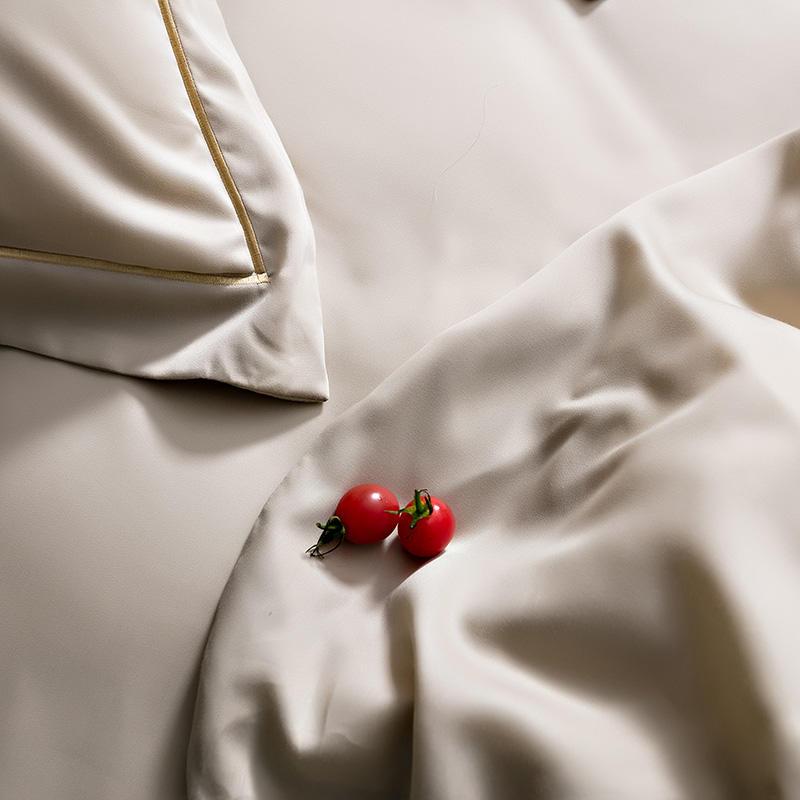Karen Solid Color Lyocell Duvet Cover Set in modern boho style, shown in soft beige with smooth, luxurious fabric and cherry tomatoes on top.