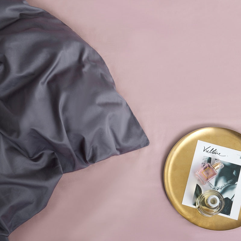 Graphite Grace Silk Duvet Cover Set (Premium Egyptian Cotton) 600TC shown on a styled bed with a magazine and perfume on a tray.