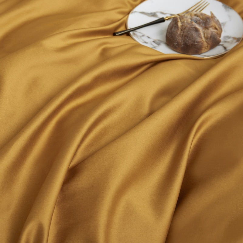 Butterscotch Grace Silk Duvet Cover Set (Premium Egyptian Cotton) 600TC in mustard color draped with pastry on plate