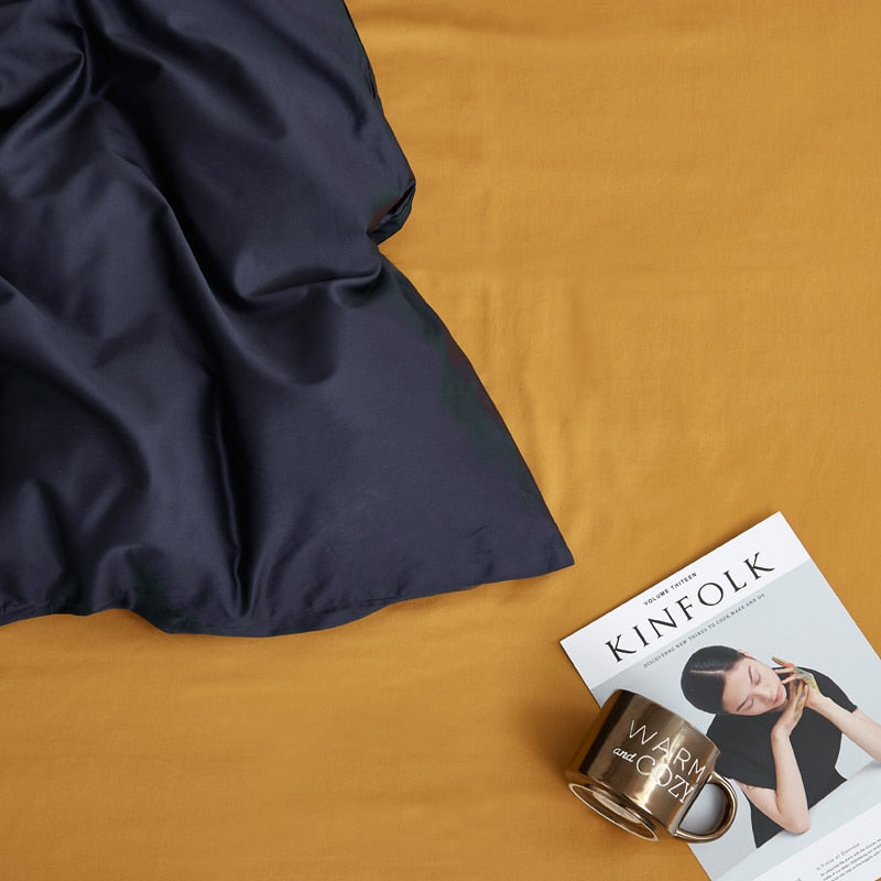 Navy Grace Silk Duvet Cover Set (Premium Egyptian Cotton) 600TC displayed on bed with magazine and mug