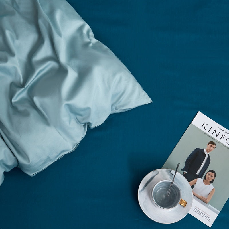 Turquoise Grace Silk Duvet Cover Set (Premium Egyptian Cotton) 600TC displayed with a magazine and coffee cup on a bed.