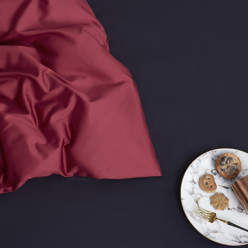 Wine Grace Silk Duvet Cover Set (Premium Egyptian Cotton) 600TC with a plate of cookies on a marble table in the background.
