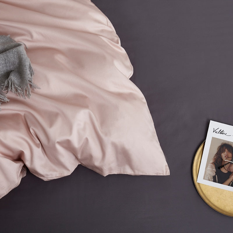 PeachPuff Grace Silk Duvet Cover Set (Premium Egyptian Cotton) 600TC on a bed with a magazine and a throw blanket.