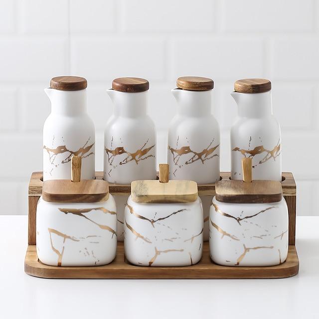Maci 8-Piece Spice Ceramic Jar With Wooden Lid set for herb and spice storage, featuring square jars and decorative lids on tray.