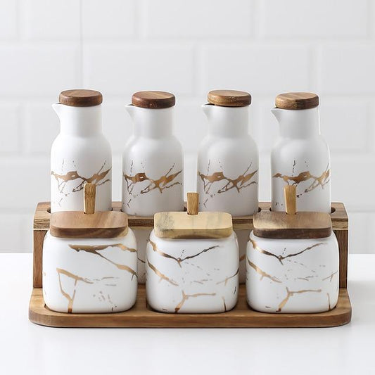 Maci 8-Piece Spice Ceramic Jar With Wooden Lid set for herb and spice storage, featuring square jars and decorative lids on tray.