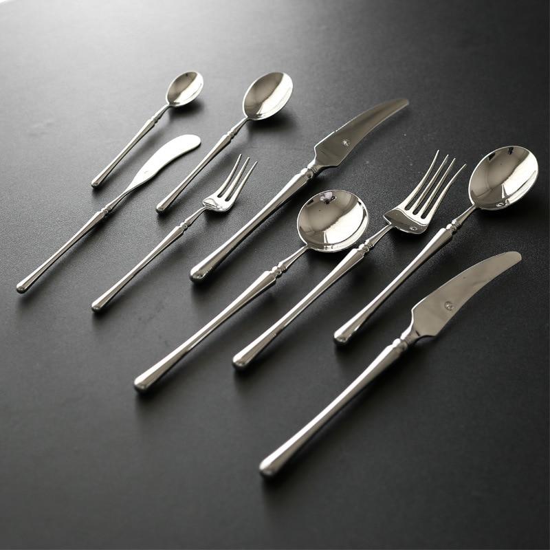 Zina Flatware Set 24-Piece (Polished) in stainless steel, mirror-finished dining utensils arranged elegantly on dark surface