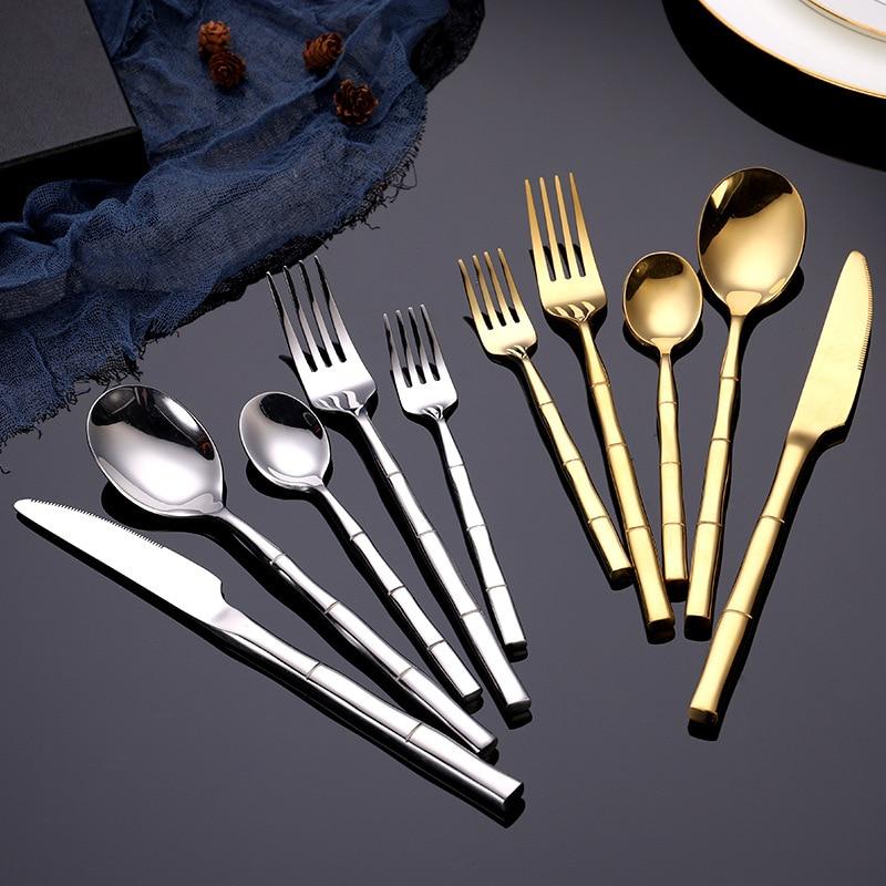 Lotus Flatware 24-Piece Set in gold and silver with bamboo style handles displayed elegantly on a table.