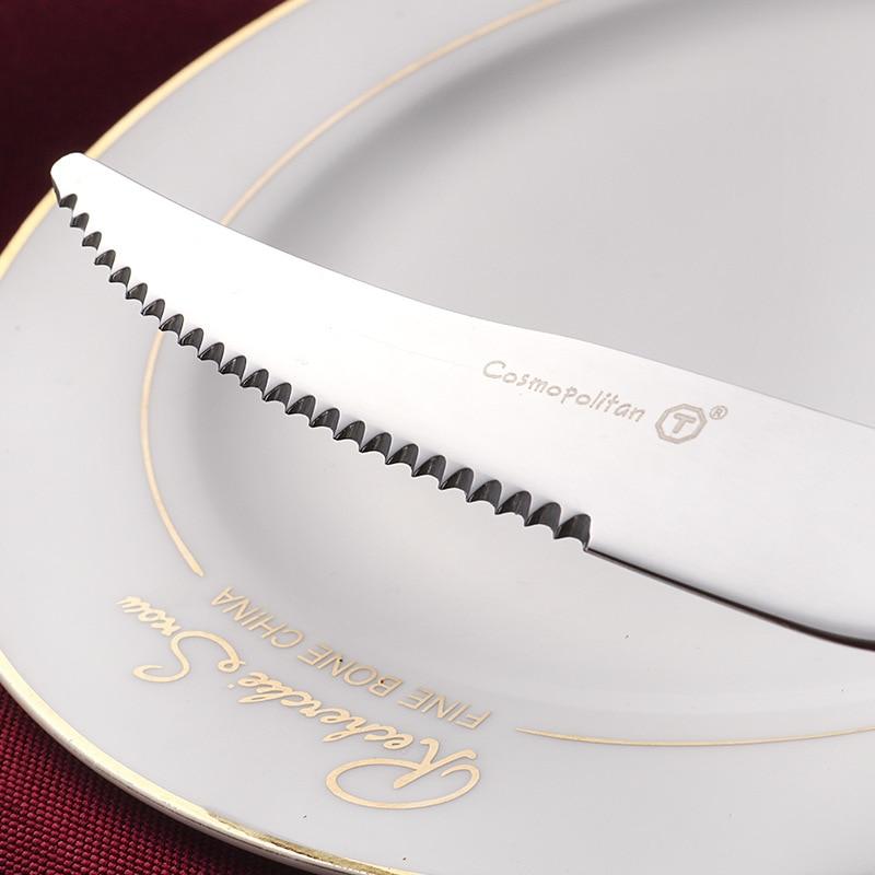 Close-up of a serrated knife from Talia Shiny Silver Flatware 24-Piece Set on an elegant dinner plate.