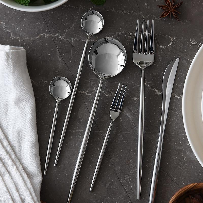 Stella 30-Piece Flatware Set with mirror-polished stainless steel design on marble table, featuring delicate oval handles.