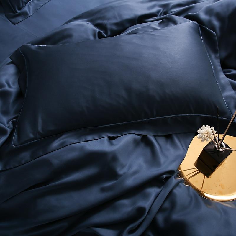 Karen Solid Color Lyocell Duvet Cover Set in navy blue, showcasing its sleek texture and modern boho style on a luxurious bed setup.