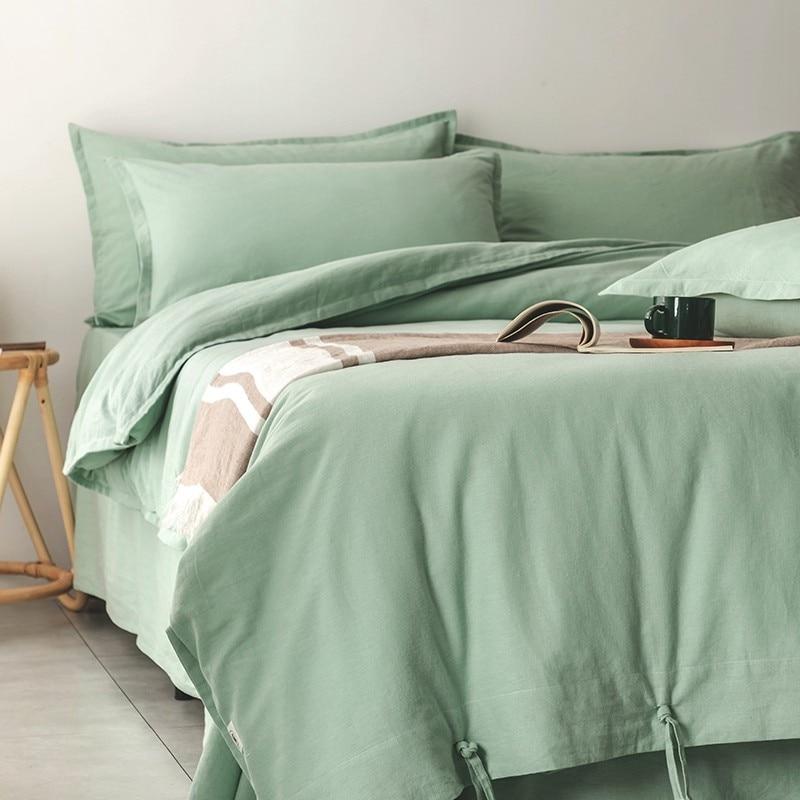Green Emma Duvet Cover Set With Ropes 55% Cotton 45% Linen on bed with cushions, book and coffee cup