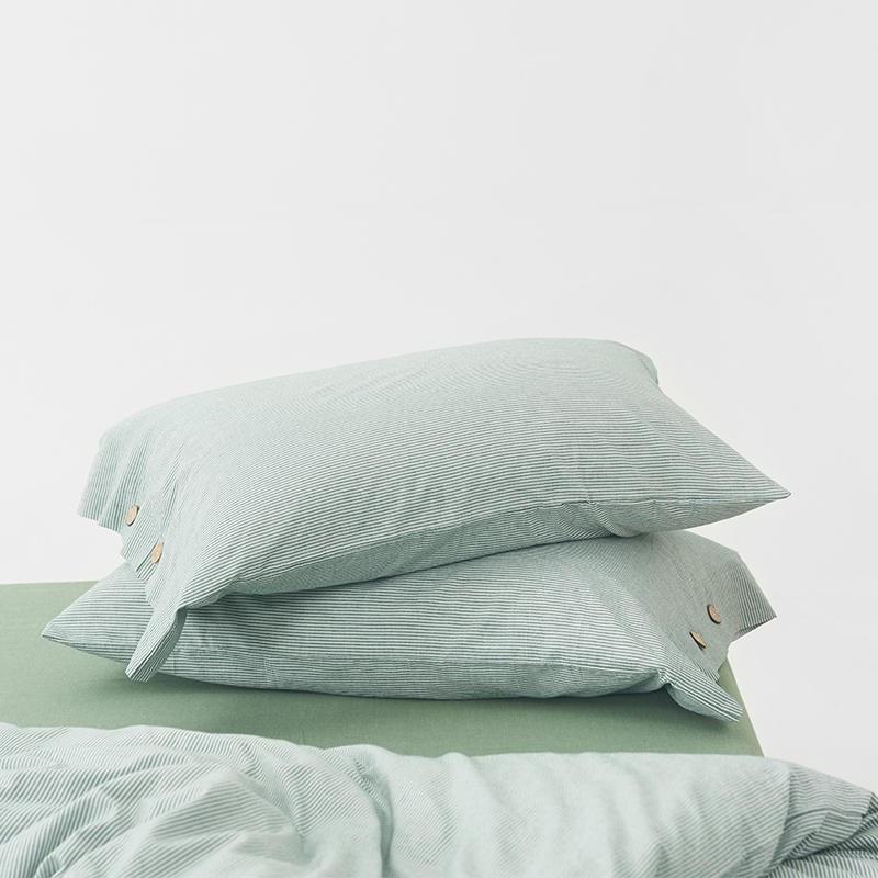 Stack of pillows with Olivia Stripe Ultra Soft Duvet Cover Set 100% Washed Cotton in soft green color with button details.
