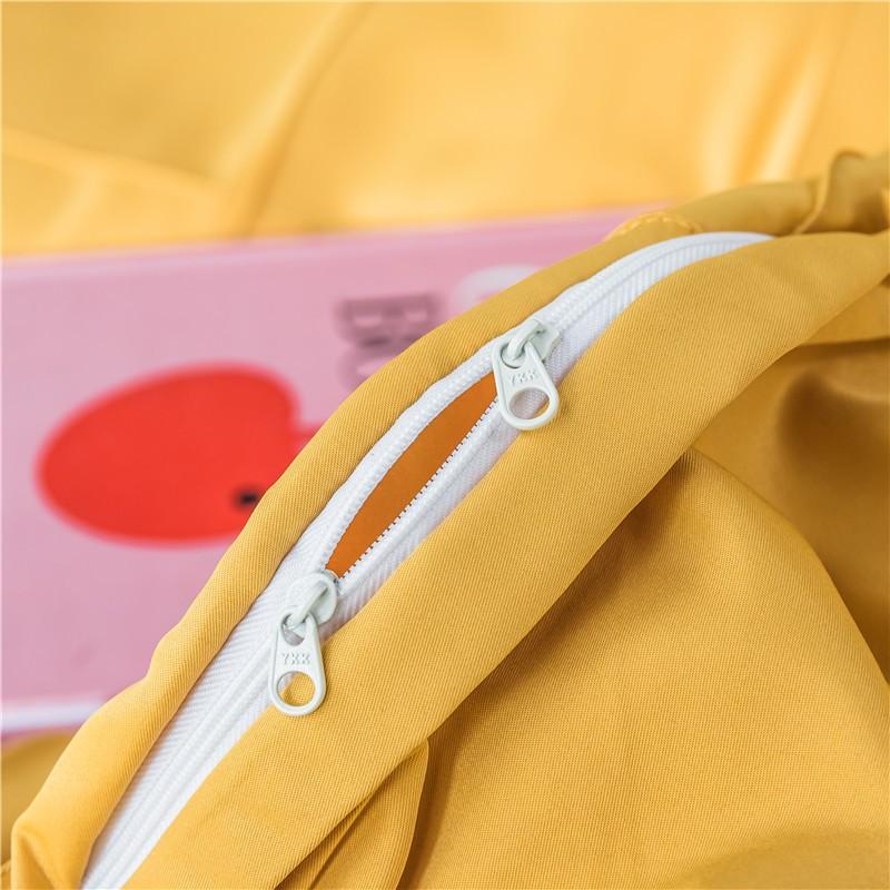 Close-up view of Charlotte Ultra Soft Microfiber Duvet Cover Set zipper detail with yellow fabric and a pink background.