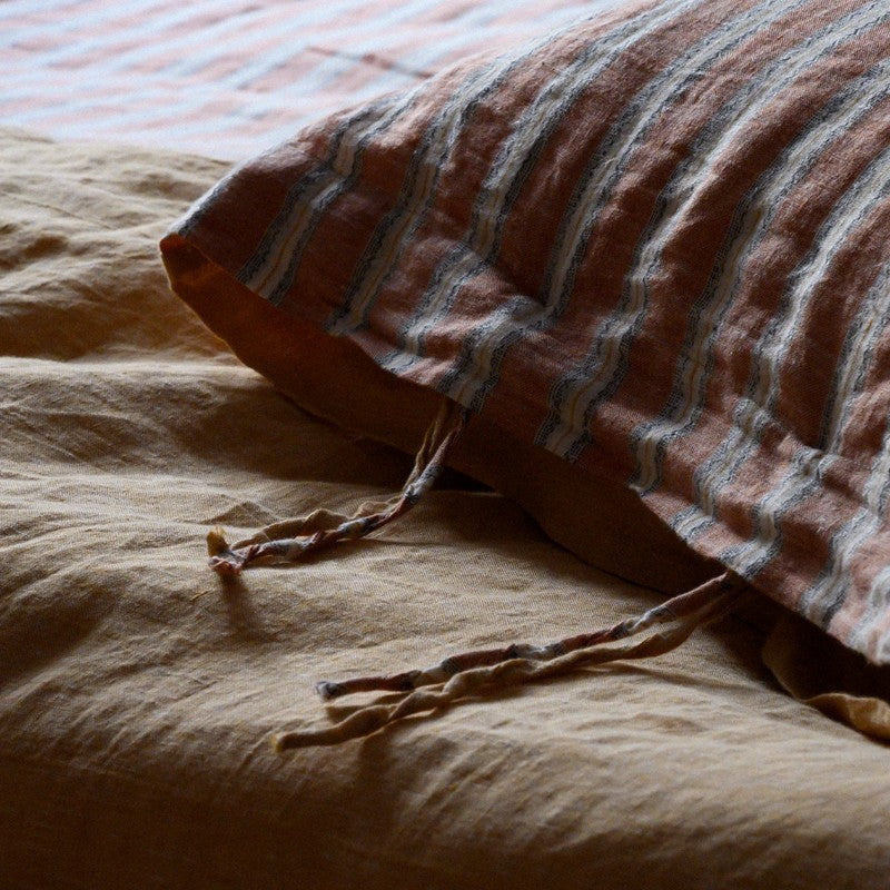 PeachPuff Vertical Stripes 100% Linen Duvet Cover Set with pillow sham on a bed, emphasizing comfort and quality in bedroom decor.