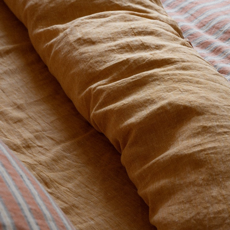 Close-up of PeachPuff Vertical Stripes 100% Linen Duvet Cover Set showcasing breathable and soft texture with a stylish design.