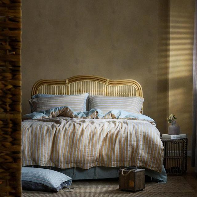 Cozy bed with PeachPuff Vertical Stripes 100% Linen Duvet Cover Set, featuring a comfortable and breathable linen bedding design.