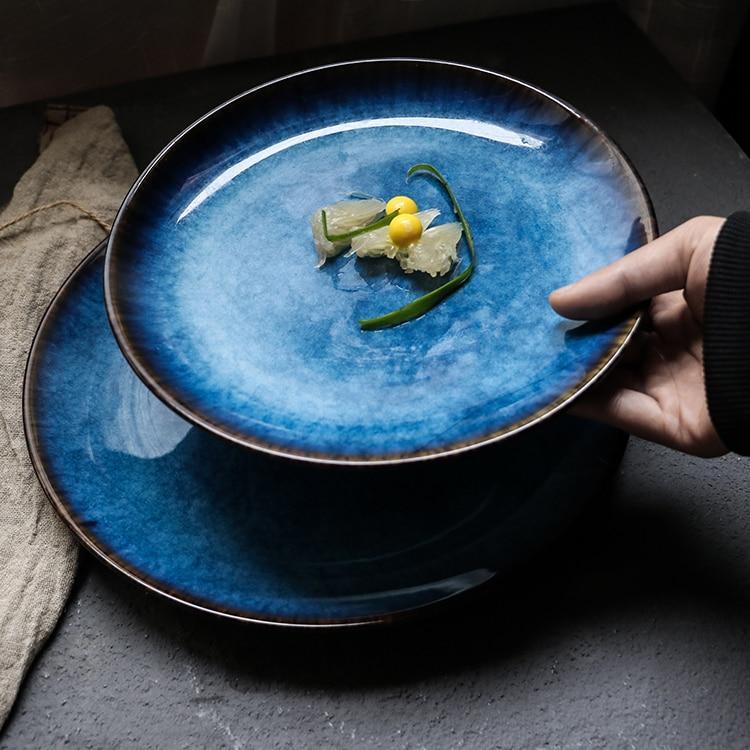 Hand-holding a ceramic Pallas Plate Set Of 4 with glaze