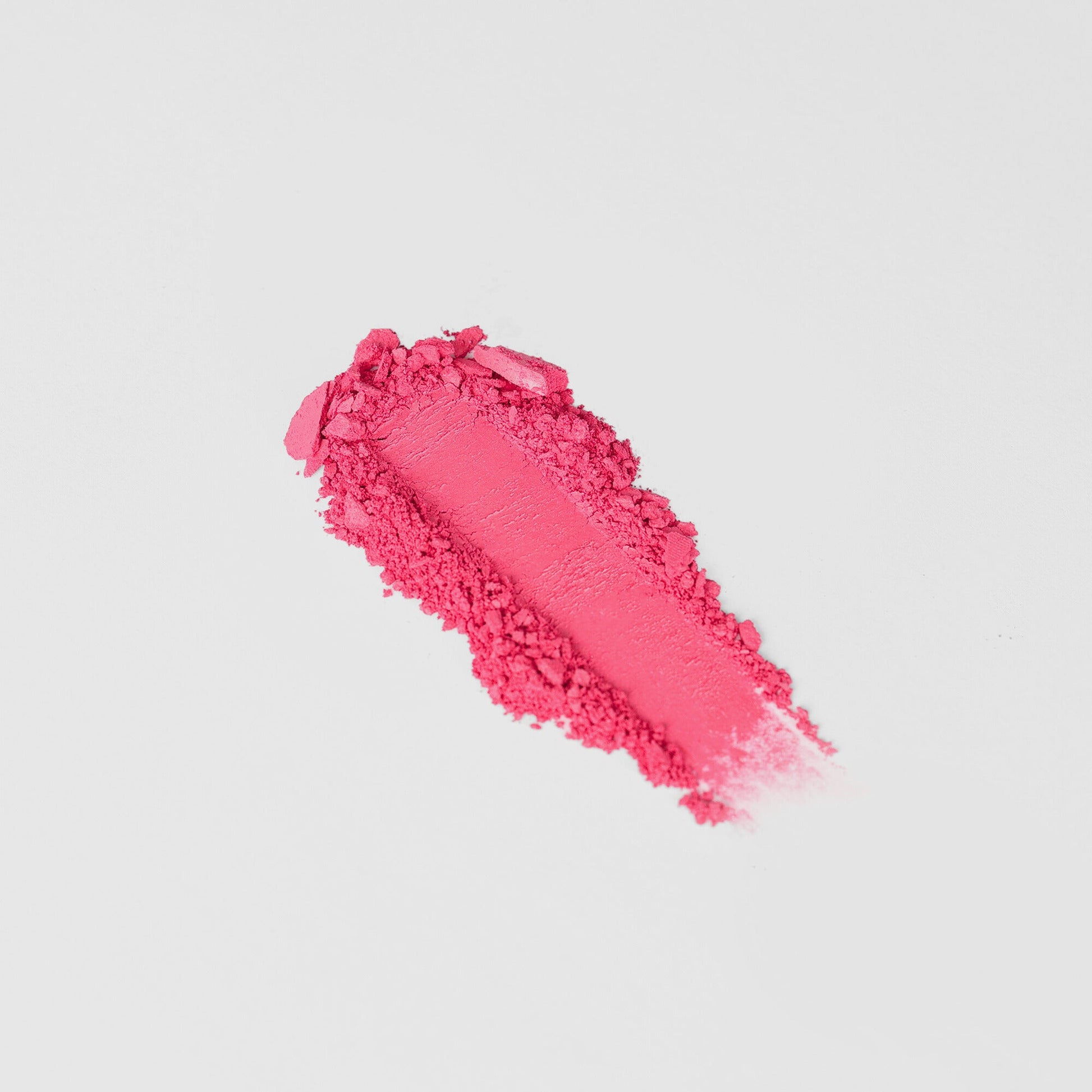Vibrant pink vegan blush swatch showcasing blendable texture for customizable color application. Perfect for all skin tones.