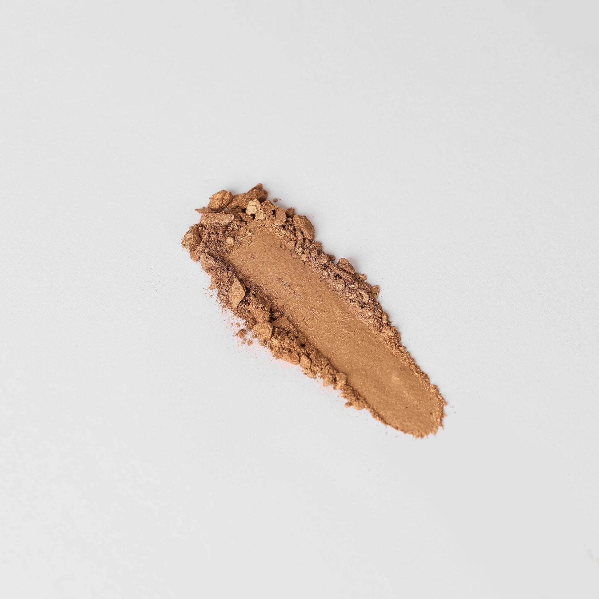 Bronzer swatch on white background showcasing blendable powder texture