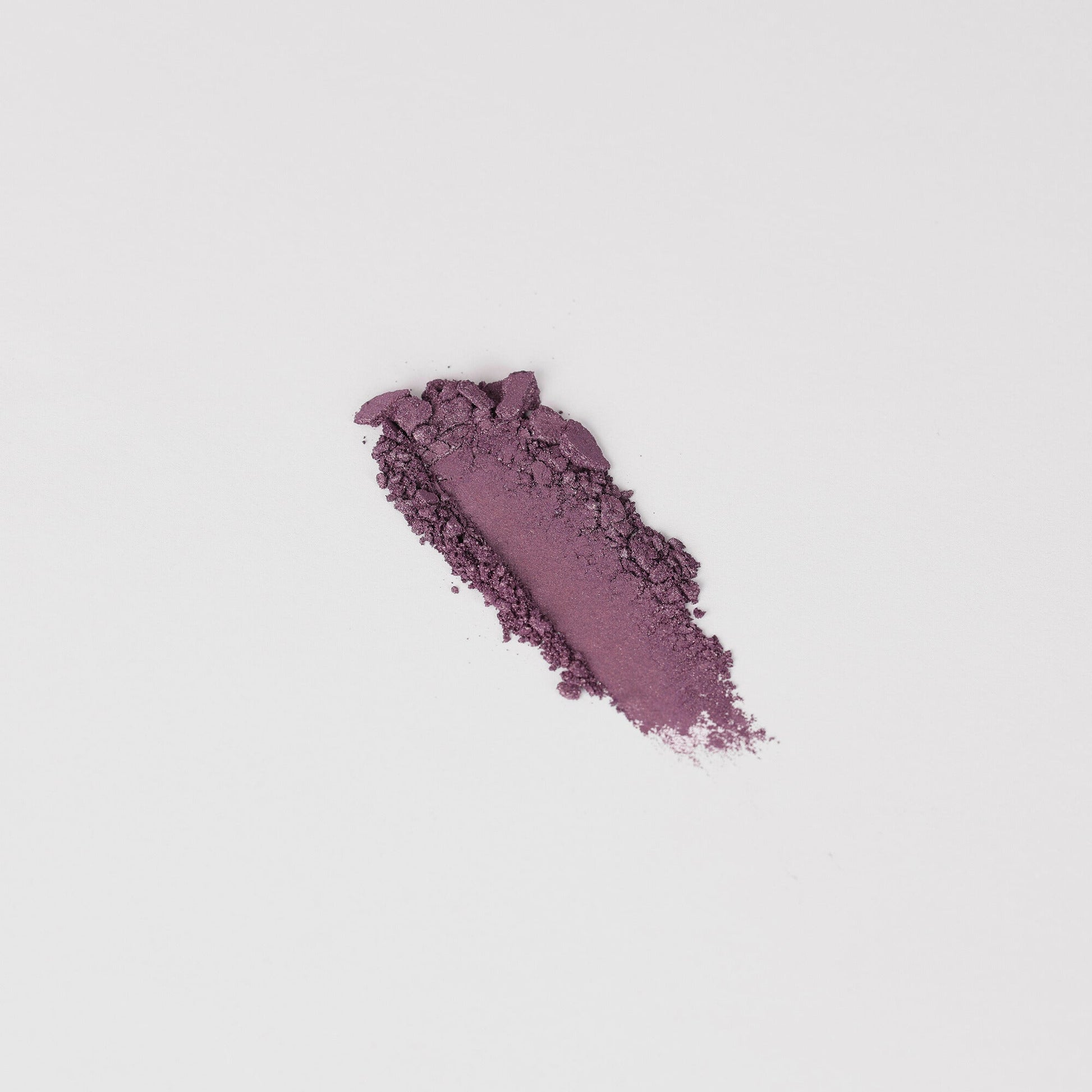 Glow Pressed Eyeshadow swatch showcasing rich purple pigment on a white background