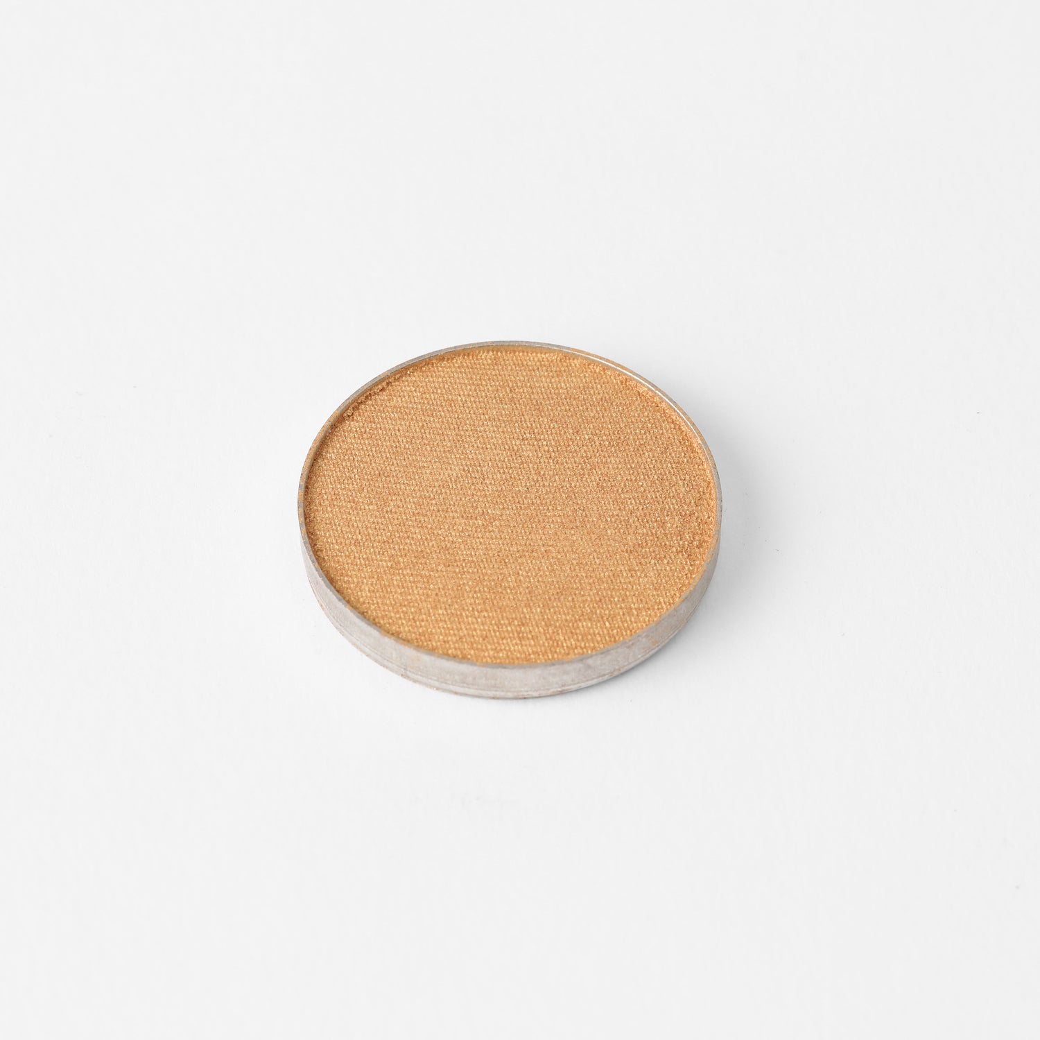Glow Pressed Eyeshadow pan in a shimmering gold color, ideal for layering and defining with rich vegan pigments.