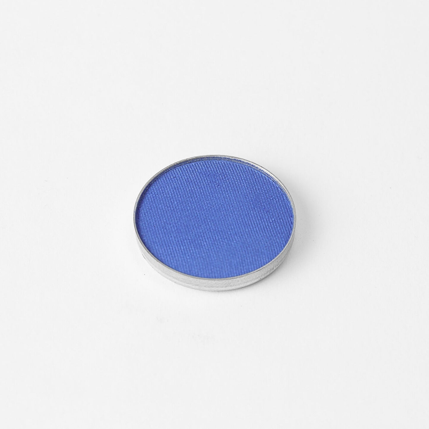 Glow Pressed Eyeshadow in rich blue pigment for buildable, long-lasting shimmer. Vegan and easy to blend. Ideal for subtle or bold looks.