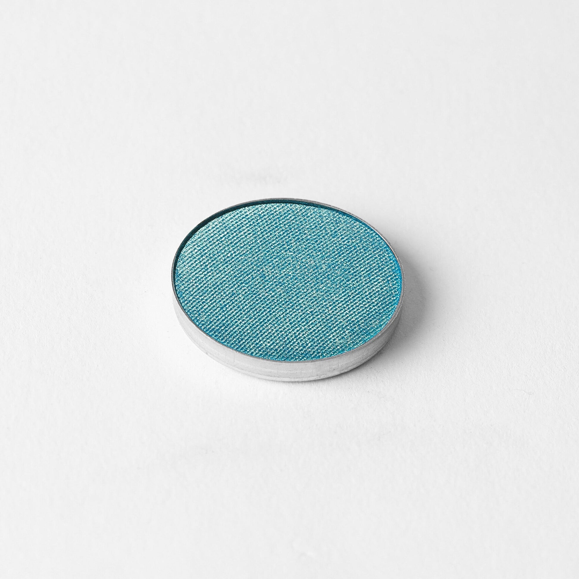Glow Pressed Eyeshadow in vibrant turquoise blue shade on a white background.